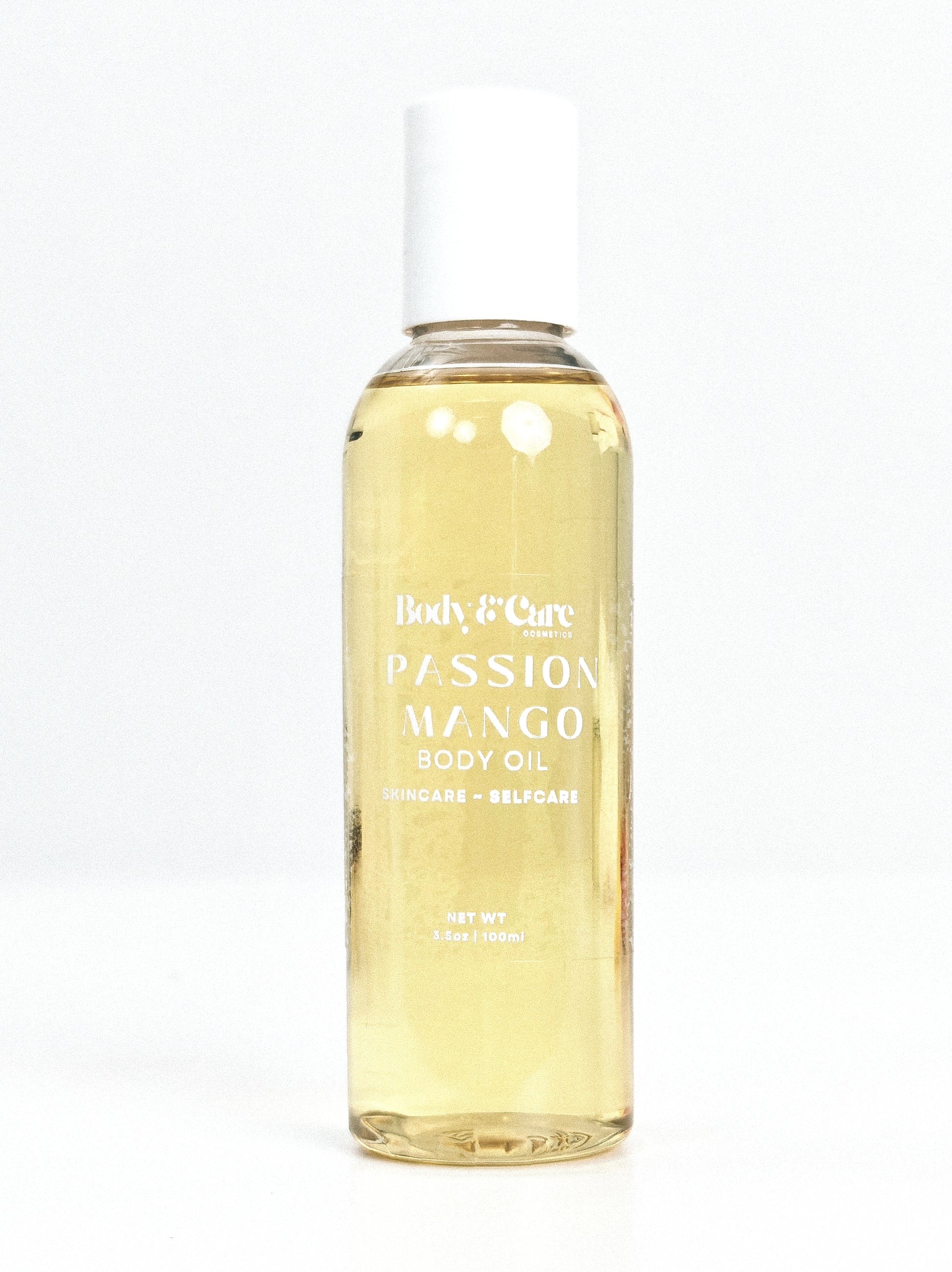 Body & Care Passion Mango Body Oil in a clear bottle with white cap on a white background.