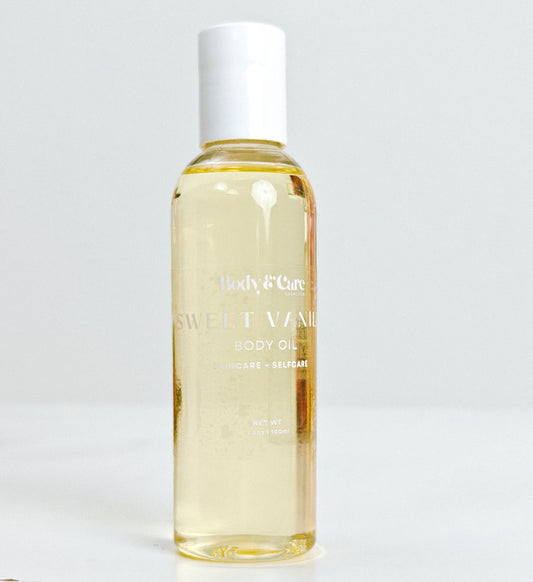 Body & Care Sweet Vanilla Body Oil in a clear bottle with white cap on a light background.