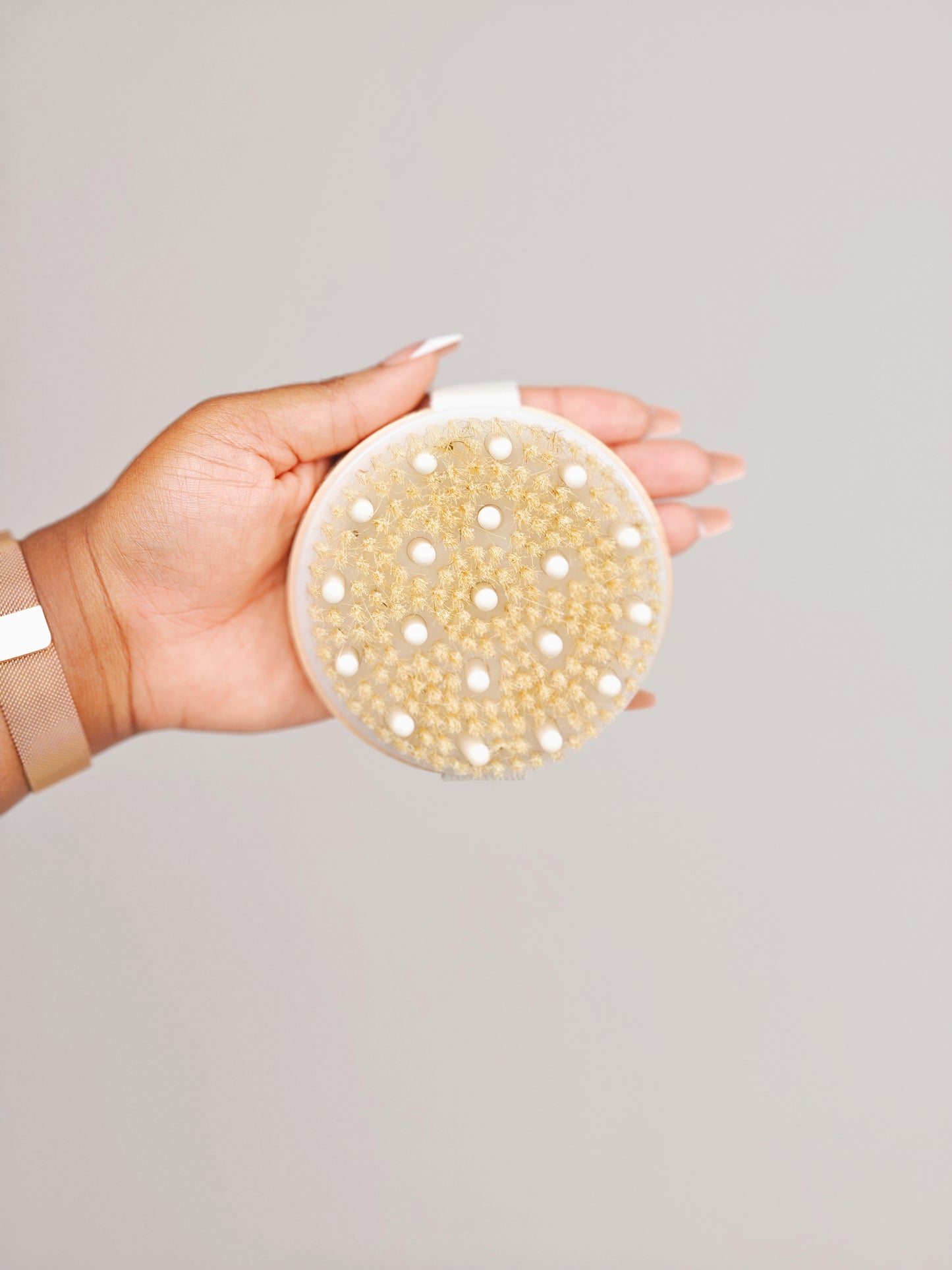Close-up of the natural bristles on a Body & Care wooden body brush held in hand.