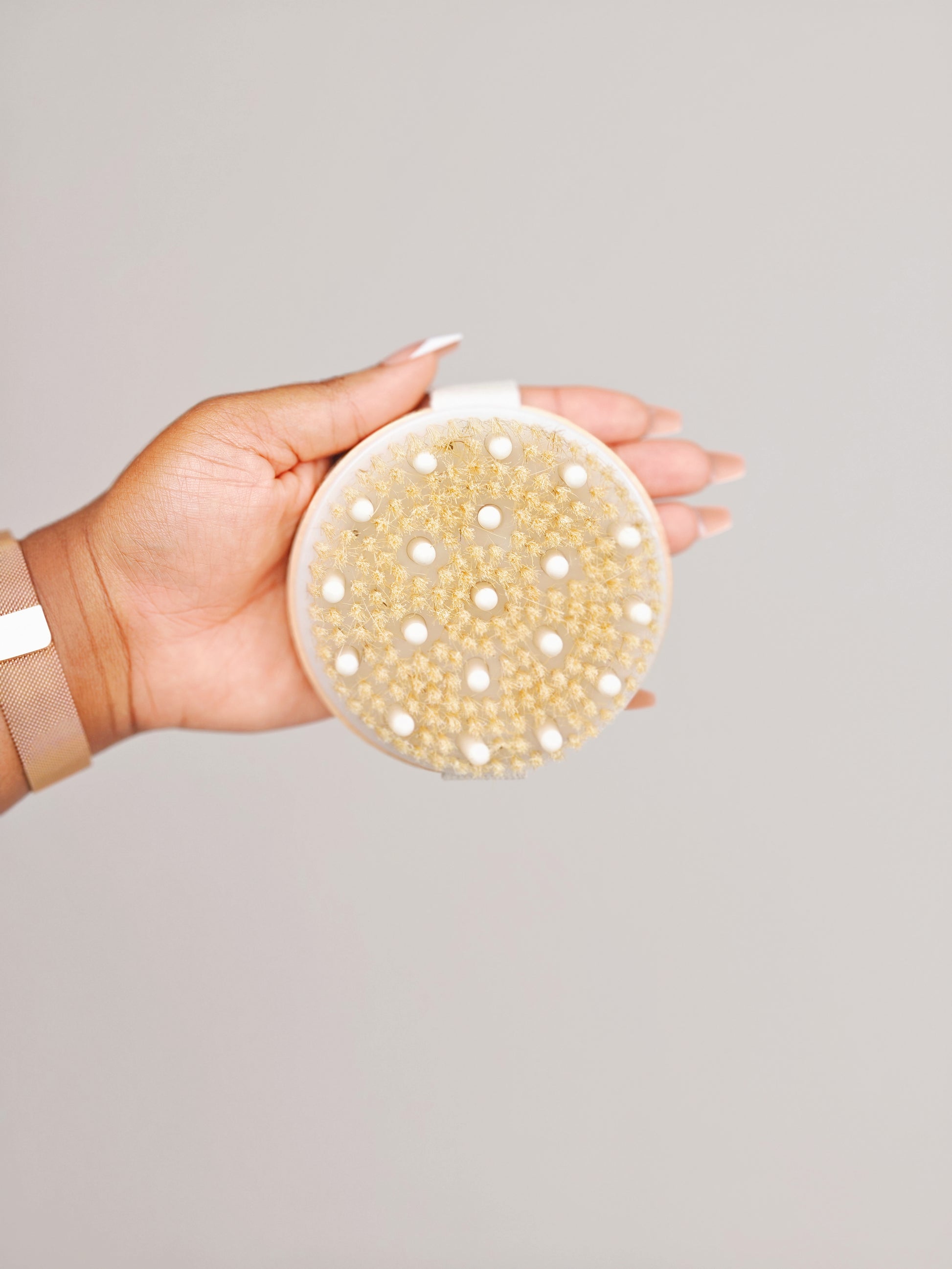 Close-up of the natural bristles on a Body & Care wooden body brush held in hand.